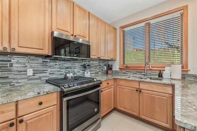 kitchen featuring a sink, decorative backsplash, appliances with stainless steel finishes, and light brown cabinets