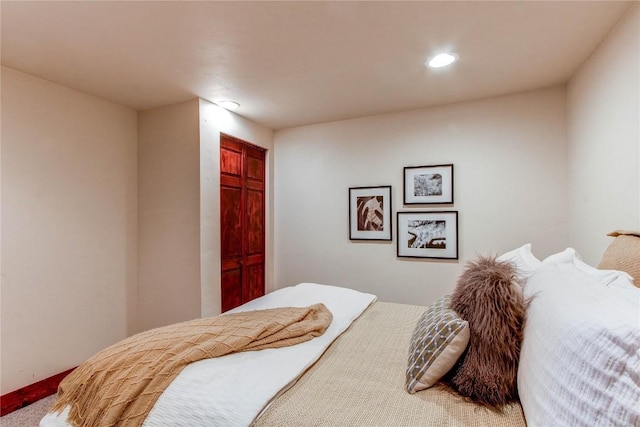 carpeted bedroom with a closet and recessed lighting