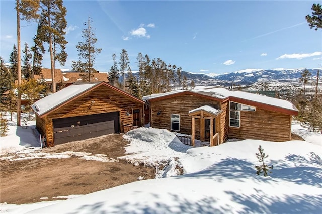log home with a garage and a mountain view