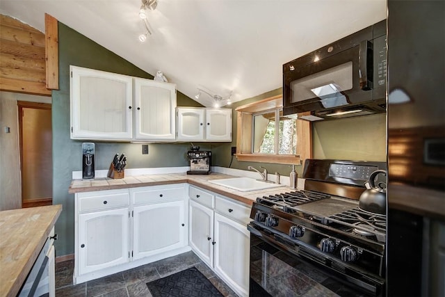 kitchen with sink, white cabinets, black appliances, and lofted ceiling