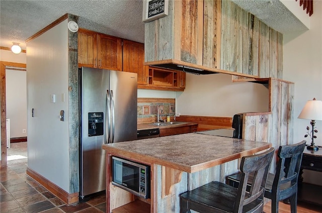 350 Old Fish Creek Falls Rd Unit 350, Steamboat Springs, CO 80487 - kitchen with appliances with stainless steel finishes, a textured ceiling, a sink, brown cabinets, and baseboards