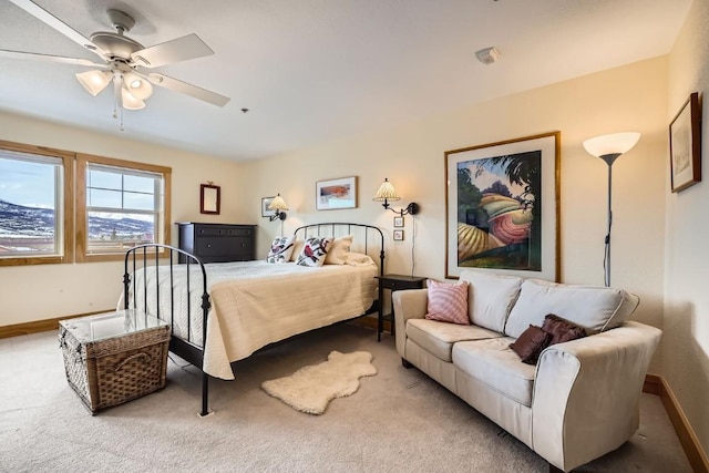 carpeted bedroom with ceiling fan and baseboards