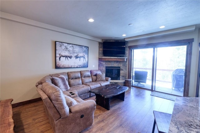 421 Rainbow Dr Unit 12, Silverthorne, CO 80498 - living area with wood finished floors, a stone fireplace, baseboards, and recessed lighting