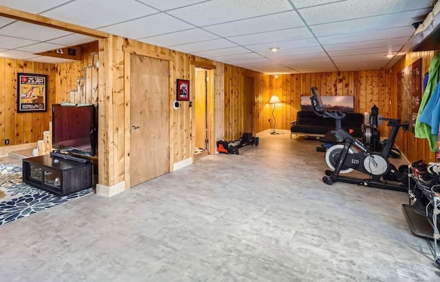 interior space with wood walls and a paneled ceiling