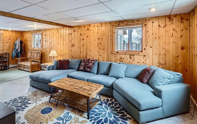 living room featuring wood walls and a paneled ceiling