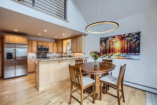 dining area featuring recessed lighting, light wood-style flooring, baseboard heating, and high vaulted ceiling