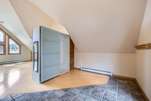 additional living space featuring baseboards, baseboard heating, wood finished floors, and lofted ceiling