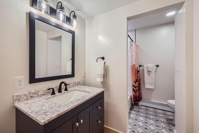 bathroom featuring toilet, baseboards, shower / tub combo, and vanity