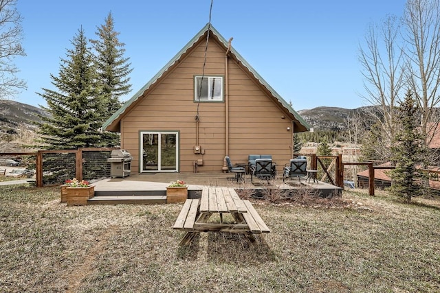 back of property with fence and a deck with mountain view
