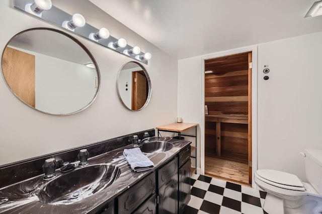 bathroom featuring a sink, tile patterned floors, toilet, and double vanity
