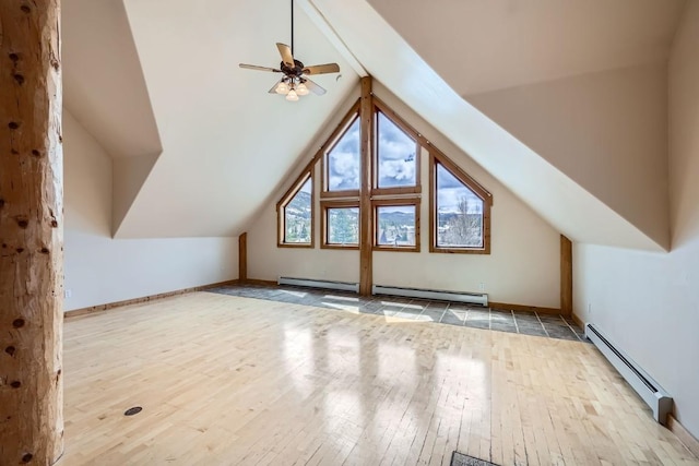 additional living space with a ceiling fan, vaulted ceiling, a baseboard radiator, a baseboard heating unit, and hardwood / wood-style floors