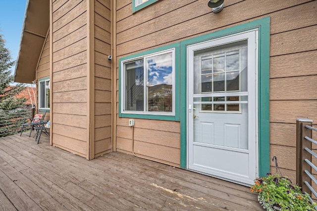 view of exterior entry featuring a wooden deck