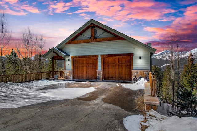 snow covered garage featuring driveway