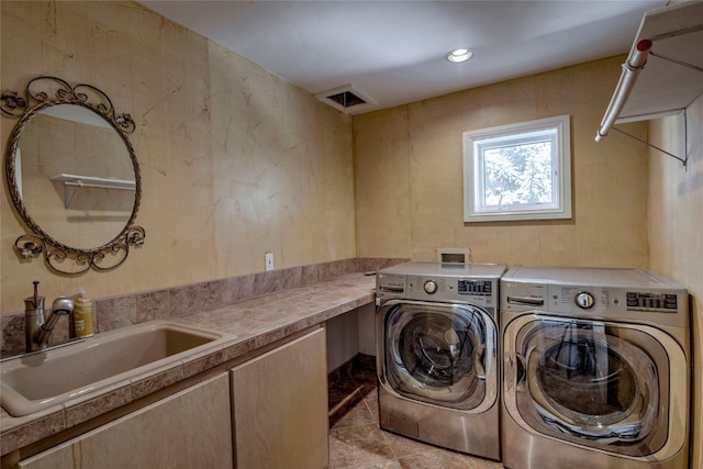 clothes washing area with laundry area, washing machine and dryer, and a sink