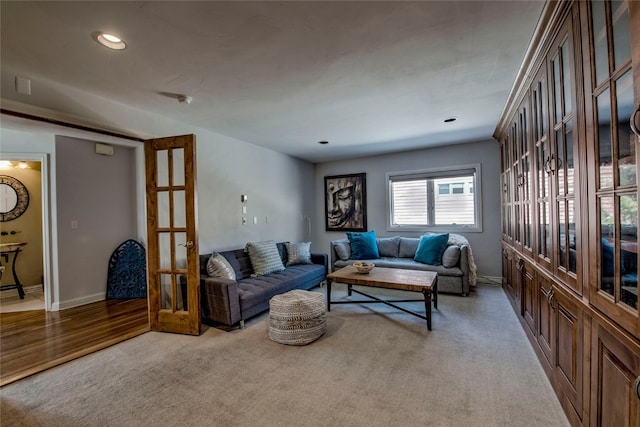 living room featuring light colored carpet, baseboards, and recessed lighting