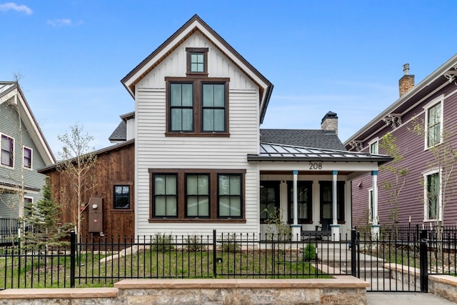 208 N Ridge St, Breckenridge, CO 80424 - view of front of property featuring covered porch, roof with shingles, a standing seam roof, a fenced front yard, and a metal roof