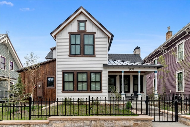 208 N Ridge St, Breckenridge, CO 80424 - modern farmhouse featuring a fenced front yard, a chimney, a shingled roof, covered porch, and a standing seam roof