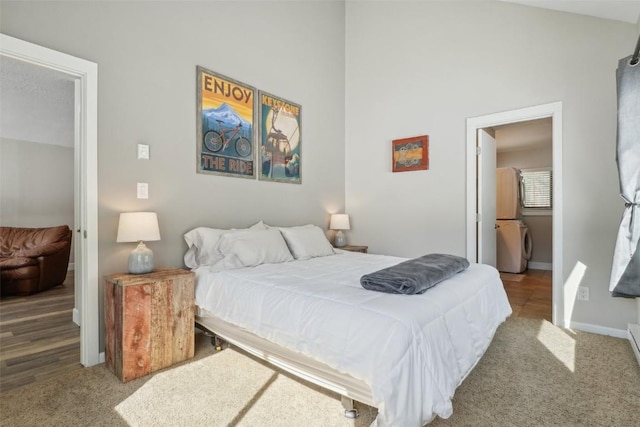 bedroom with washer / dryer, baseboards, carpet floors, and vaulted ceiling