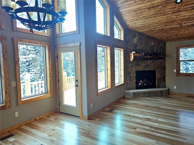 unfurnished living room featuring wooden ceiling, wood finished floors, a fireplace, baseboards, and high vaulted ceiling
