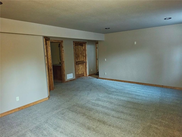 carpeted empty room with a textured ceiling, visible vents, recessed lighting, and baseboards