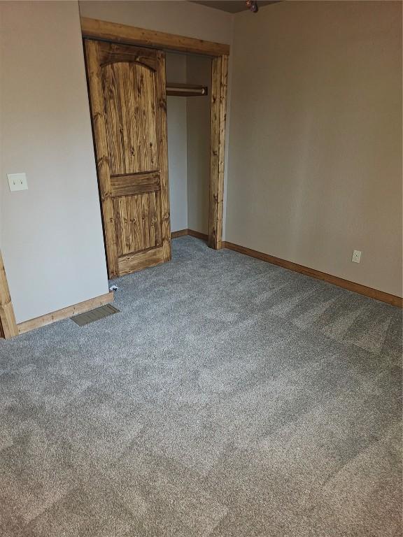 carpeted spare room with baseboards