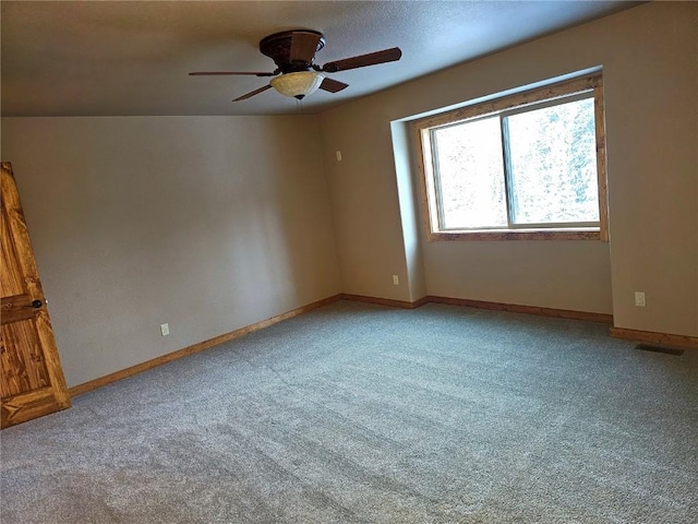 unfurnished room featuring a ceiling fan, light colored carpet, and baseboards
