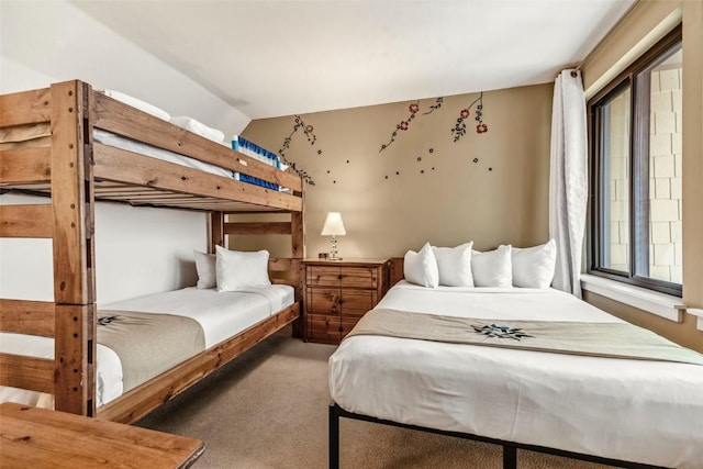 carpeted bedroom with lofted ceiling