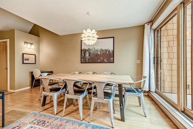 dining room featuring a chandelier, light wood finished floors, baseboards, and baseboard heating