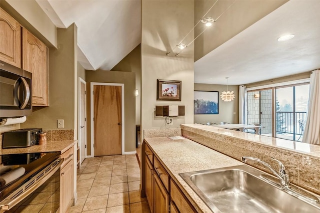 kitchen with light tile patterned floors, appliances with stainless steel finishes, a sink, and light countertops
