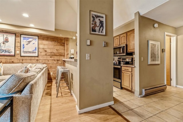 kitchen featuring light countertops, baseboards, appliances with stainless steel finishes, and open floor plan