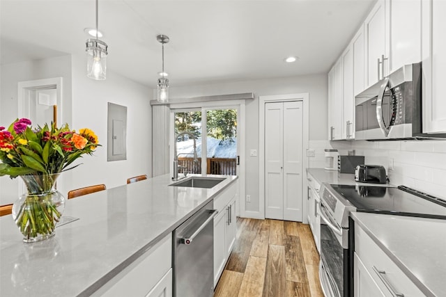 112 Illinois Gulch Rd Unit 6, Breckenridge, CO 80424 - kitchen with light wood-style floors, tasteful backsplash, appliances with stainless steel finishes, and white cabinetry