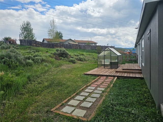 21762 4th Ave, Phippsburg, CO 80469 - fenced backyard featuring a wooden deck, a greenhouse, and an outbuilding