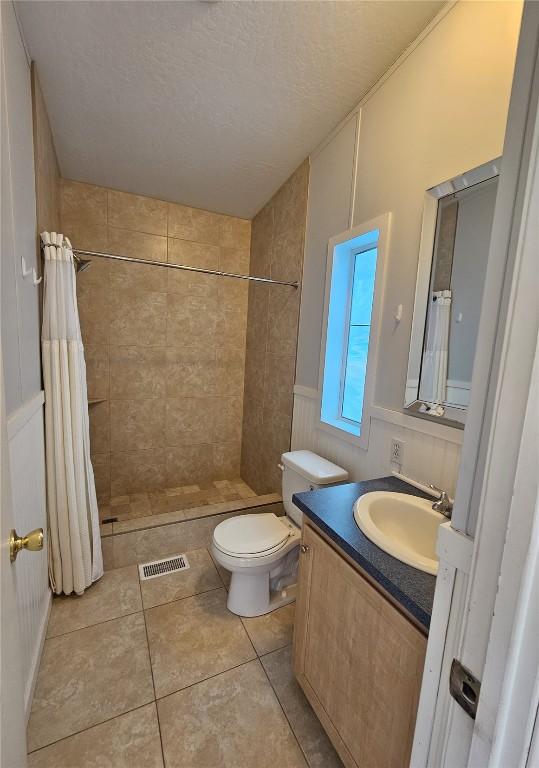 21762 4th Ave, Phippsburg, CO 80469 - full bathroom with tiled shower, vanity, tile patterned flooring, and a textured ceiling
