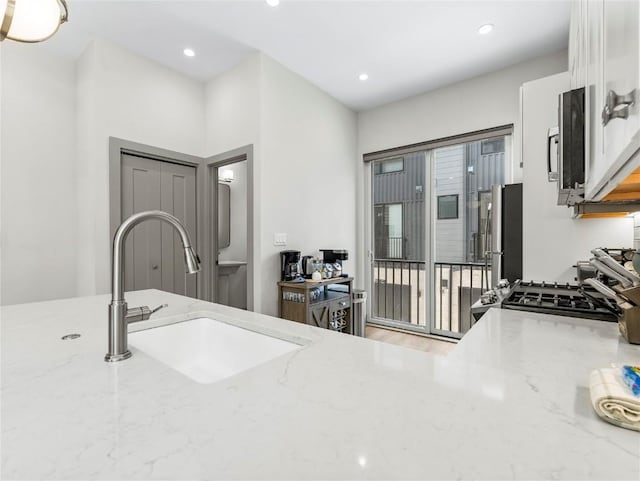 62 W 3rd St Unit D, Silverthorne, CO 80498 - kitchen featuring stainless steel appliances, white cabinets, light stone counters, recessed lighting, and wood finished floors
