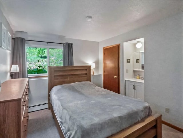 9876 Ryan Gulch Rd Unit 106, Silverthorne, CO 80498 - carpeted bedroom with a baseboard heating unit, a sink, ensuite bathroom, and baseboards
