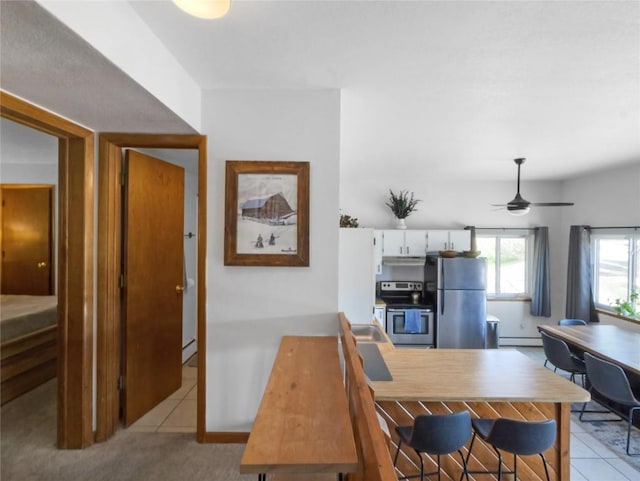 9876 Ryan Gulch Rd Unit 106, Silverthorne, CO 80498 - kitchen featuring stainless steel appliances, a baseboard heating unit, white cabinets, and light tile patterned flooring