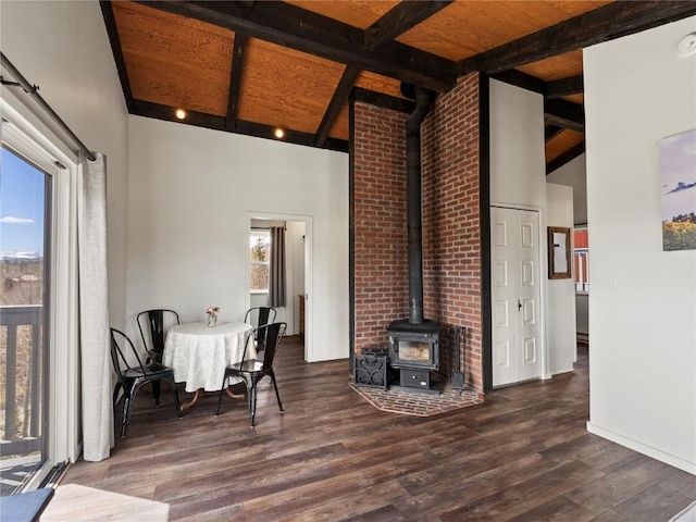 8012 Ryan Gulch Rd Unit B3, Silverthorne, CO 80498 - dining area featuring a wood stove, wood finished floors, beamed ceiling, baseboards, and high vaulted ceiling