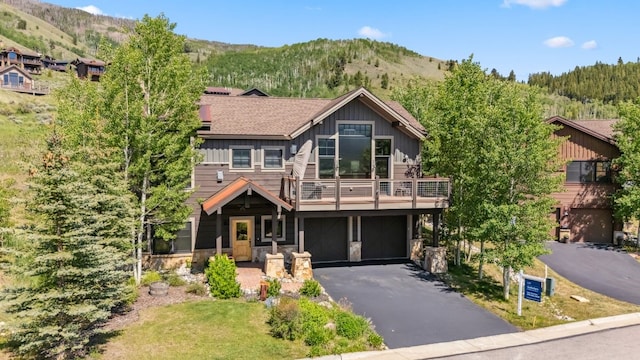 52 Buckskin Ln, Silverthorne, CO 80498 - rustic home with a mountain view, board and batten siding, asphalt driveway, and an attached garage