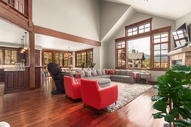 168 Corkscrew Dr, Breckenridge, CO 80424 - living room with a chandelier, a stone fireplace, wood finished floors, high vaulted ceiling, and healthy amount of natural light