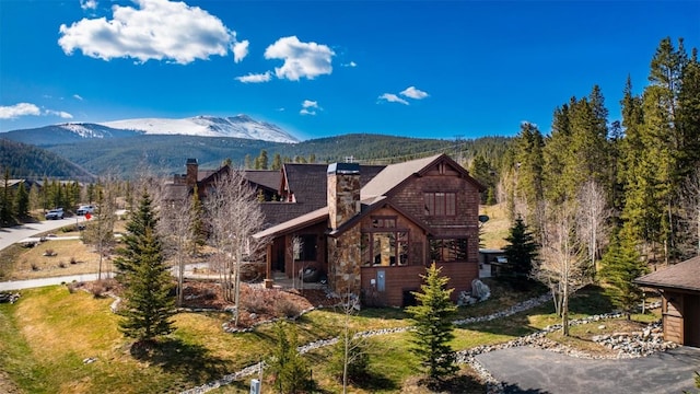 168 Corkscrew Dr, Breckenridge, CO 80424 - view of front facade with a chimney, a mountain view, and stone siding
