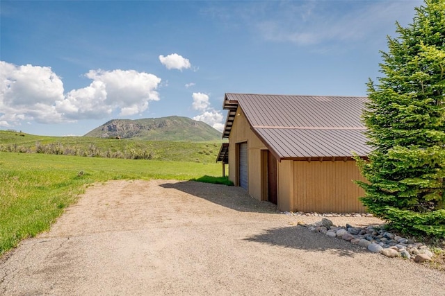 23125 Fawn Creek Rd, Steamboat Springs, CO 80487 - view of grassy yard featuring an outbuilding, a mountain view, and a detached garage