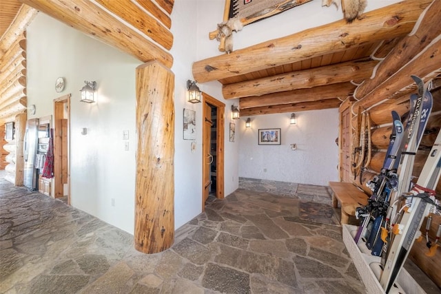 23125 Fawn Creek Rd, Steamboat Springs, CO 80487 - hall with stone flooring, beamed ceiling, and rustic walls