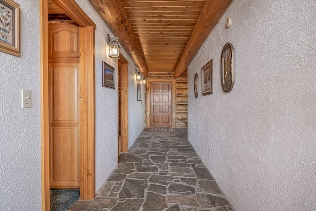 23125 Fawn Creek Rd, Steamboat Springs, CO 80487 - hallway featuring wood ceiling, stone flooring, rustic walls, and a textured wall
