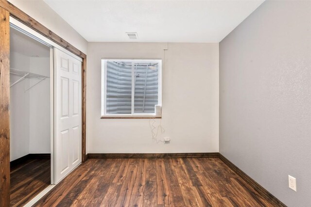 21775 4th Ave, Phippsburg, CO 80469 - unfurnished bedroom featuring dark wood-style floors, baseboards, and a closet