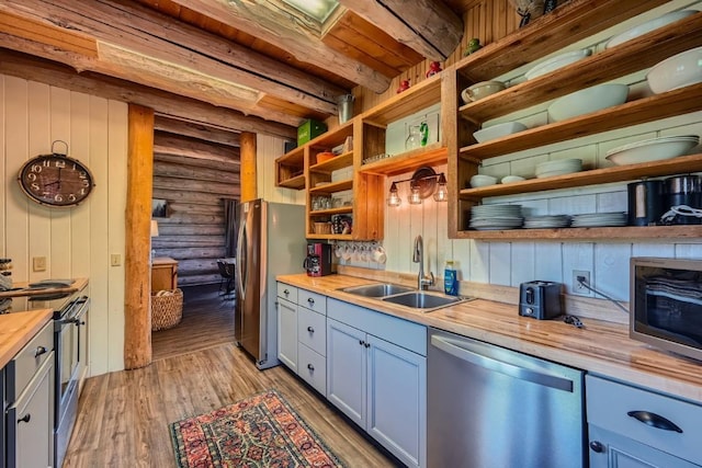 922 Braddock Dr, Breckenridge, CO 80424 - kitchen featuring stainless steel appliances, butcher block counters, open shelves, rustic walls, and light wood-type flooring