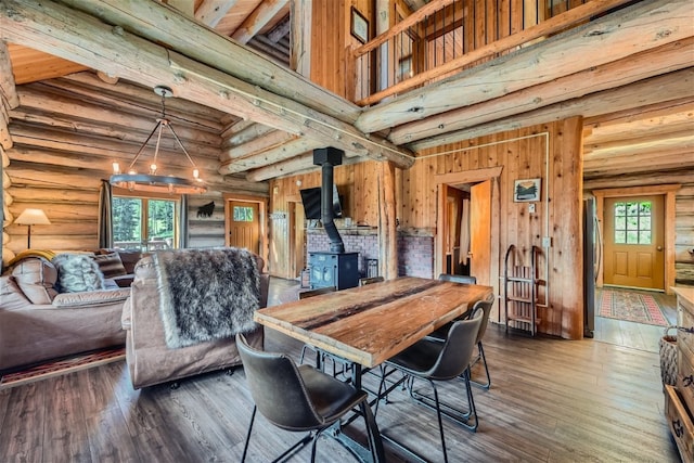 922 Braddock Dr, Breckenridge, CO 80424 - dining area featuring a wood stove, wood finished floors, log walls, a high ceiling, and beamed ceiling