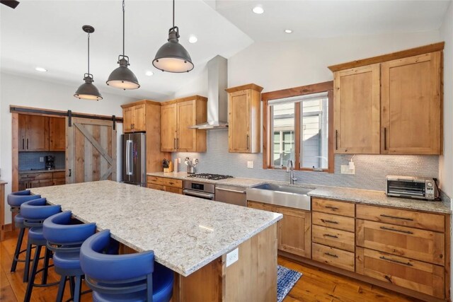 481 W Main St Unit A201, Frisco, CO 80443 - kitchen featuring a barn door, a sink, stainless steel appliances, wall chimney exhaust hood, and a kitchen island