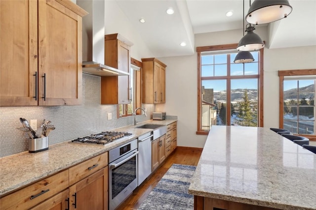 481 W Main St Unit A201, Frisco, CO 80443 - kitchen featuring light stone counters, wall chimney range hood, decorative backsplash, and stainless steel appliances