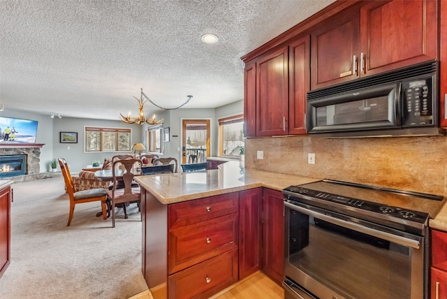 kitchen with a peninsula, open floor plan, a notable chandelier, black microwave, and electric stove