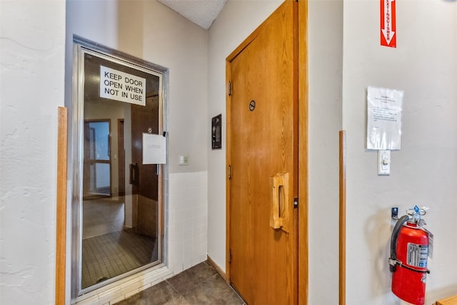 corridor featuring dark tile patterned flooring